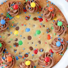 a cake with chocolate frosting and sprinkles in a white dish on a table