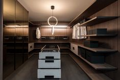 a walk - in closet with shelves, drawers and clothes hanging on the wall next to it