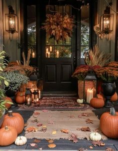 a front porch decorated with pumpkins and candles