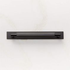 a black drawer handle on a white wall