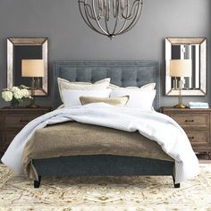 a large bed sitting under a chandelier in a bedroom