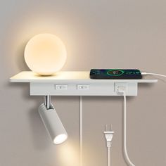 a light that is on top of a shelf with some wires attached to the wall