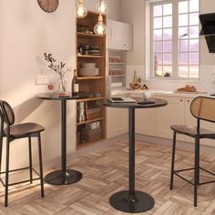 two chairs and a table in a room with wood flooring, white walls and cabinets