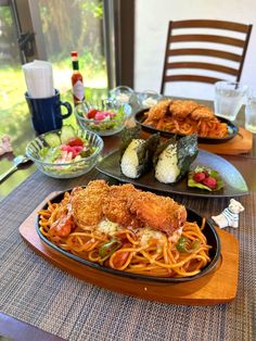 three plates of food on a table in front of a glass window with an outside view