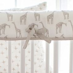 a baby crib with giraffes and stars on it's side