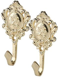 pair of gold plated wall hooks with an ornate design on each hook and the image of queen elizabeth