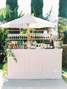 an outdoor bar with bottles and glasses on it