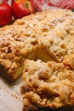 a close up of a pie on a table with apples in the backround