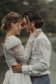 a man and woman standing next to each other in the rain