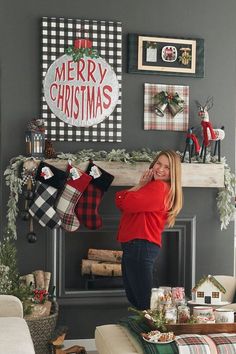 a woman standing in front of a fireplace with stockings hanging from it's mantle