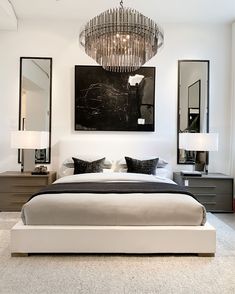 a bedroom with a chandelier hanging above the bed