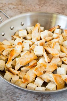 a pan filled with chicken and potatoes on top of a counter