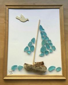 a painting with sea glass and a wooden stick in the shape of a sailboat