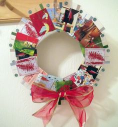 a wreath made out of magazines with a red bow hanging on the front door wall