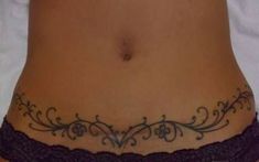 a woman's stomach with an intricate tattoo on her lower body and bottom part