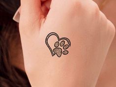 a woman's arm with a tattoo on it that has a dog paw in the shape of a heart