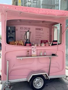 a pink ice cream truck parked on the side of the road with drinks and snacks in it