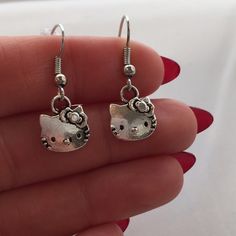 Silver Hello Kitty Earrings Hypoallergenic Hooks! These adorable Hello Kitty dangle earrings are made of Tibetan silver and are on hypoallergenic hooks that won’t hurt your ears. Signed on the back. They are brand new, handmade, and never been worn. Lead and nickel free. Rubber backs included. These fine quality earring are perfect and comfortable for all day, everyday wear or a special gift.   Send offers and questions. Hello Kitty Jewelry Earrings Hello Kitty Jewelry Earrings, Silly Earrings, Hello Kitty Earrings, Y2k Hello Kitty, Hello Kitty Jewelry, Earrings Hypoallergenic, Hello Kit, All Day Everyday, Hello Kitty Pictures