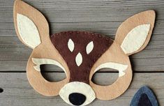 a deer mask is sitting on a wooden surface next to a pair of blue shoes