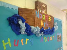 a classroom wall decorated with blue and white paper streamers that read noah's ark