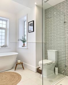 a bathroom with a toilet, bathtub and rug in front of the shower door