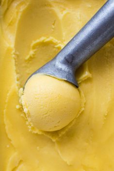 a scoop of yellow ice cream with a metal handle