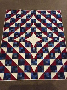 a red, white and blue quilt on the floor