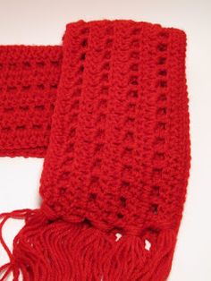 two red knitted scarves sitting on top of a white table next to each other