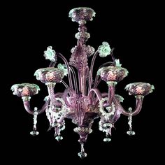 a purple chandelier with lots of glass flowers hanging from it's sides