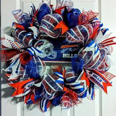 a football wreath is hanging on a door with the buffalo bills logo and red, white, and blue streamers