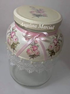 a glass jar with pink roses on it and a ribbon tied around the lid that says angelina material