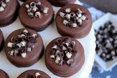 chocolate covered cookies with white and brown toppings on a cake platter, ready to be eaten