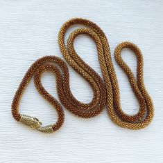 This is a handmade gold snake necklace from high-quality seed beads, cotton yarn with a snake head and tail clasps (jewelry hypoallergenic aluminum) is very flexible and comfortable to wear. * MEASUREMENTS: Necklace Length on photo: 55.11 inches (139 cm). Custom length available! Custom colors available! * WHOLESALE AVAILABLE! * This snake necklace could be lovely accessorize for your look every day, or special evening. This long necklace also is a perfect accessory, which can be worn formally o Handmade Multi-strand Gold Chain Necklace, Gold Multi-strand Beaded Necklaces With Lobster Clasp, Gold Multi-strand Beaded Necklace With Lobster Clasp, Handmade Gold Snake Jewelry, Handmade Gold Snake-shaped Necklace, Handmade Gold Snake Necklace, Beaded Snake Chain Jewelry For Gifts, Beaded Snake Chain Jewelry Gift, Gold Beaded Necklaces With Lobster Clasp For Jewelry Making