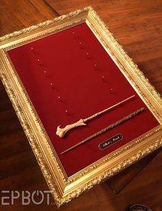 an old fashioned framed object with a long stick in it's center on a wooden floor