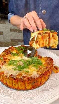 a person cutting into a deep dish pizza on a plate with a knife and fork