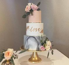 a three tiered wedding cake with flowers on the top and an elephant figurine next to it