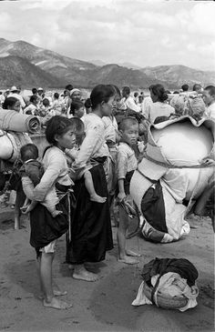 a group of people standing around each other in front of a mountain range with bags on their heads