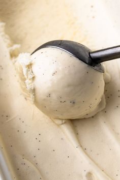 a scoop of ice cream in a bowl with a black spoon sticking out of it