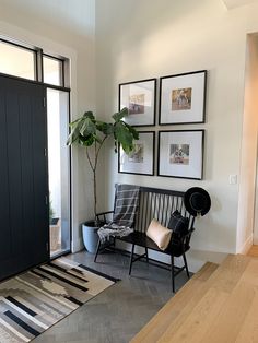 a living room with pictures on the wall and a bench in front of a door