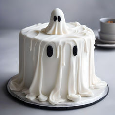 a cake with white icing and black eyes on the top is decorated like a ghost