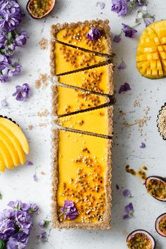 a piece of food that is on top of some kind of table with fruit and flowers around it