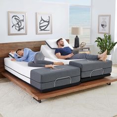 two men laying on top of mattresses in a living room next to each other