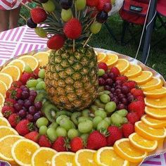 a platter filled with lots of fruit on top of a table