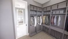 a large walk in closet with lots of clothes