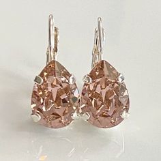 These gorgeous earrings display dazzling Vintage Rose crystal teardrops set in silver-plated bezels on silver lever back earrings.  Perfect for that special occasion! Details: * Premium European Crystal Vintage Rose Teardrops- 1/2x3/8"(14x10mm) * Silver-plated bezels and Earrings * Length- 4/5"(20mm) * Nickel  and Lead-free These earrings come in a jewelry bag and gift box. Sterling Silver Rose Gold Teardrop Earrings, Rose Gold Sterling Silver Teardrop Earrings, Teardrop Silver Earrings, Rose Crystal, Teardrop Dangle Earrings, Rose Vintage, Earring Display, Earrings Minimalist, Vintage Rose