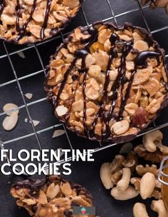 several cookies with chocolate drizzled on top and nuts in the middle, sitting on a cooling rack