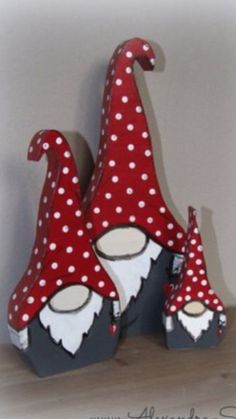 two red and white gnome hats sitting on top of a wooden table