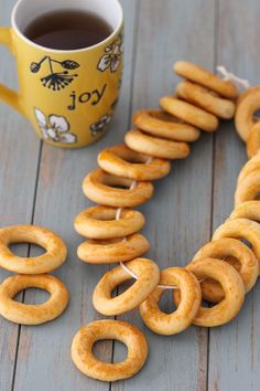 some pretzels and a cup of coffee on a wooden table with the word joy spelled out