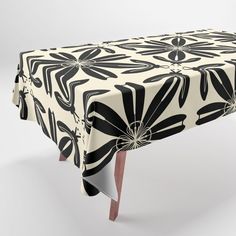 a black and white table cloth with an abstract design on the top, sitting on a wooden leg