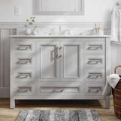 a bathroom vanity with drawers, mirror and towel rack on the wall next to it